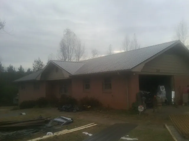Gray metal roof on a stucco house with an attached garage in Cicero
